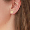 Gold lotus flower stud on models ear