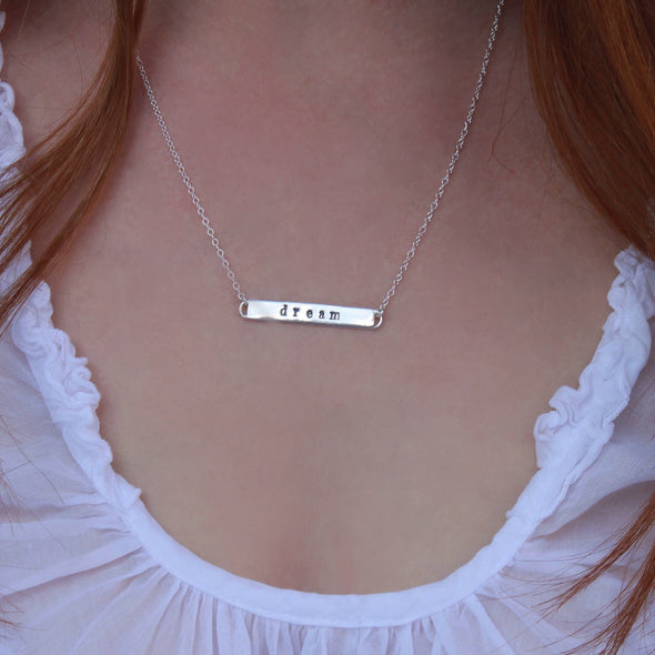 Sterling silver message dream necklace on neck.