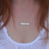 Sterling Silver hand-stamped 'love' necklace on neck.