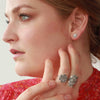 Medium and Large Sterling silver mandala rings on fingers.  Flower stud earring on models ear.