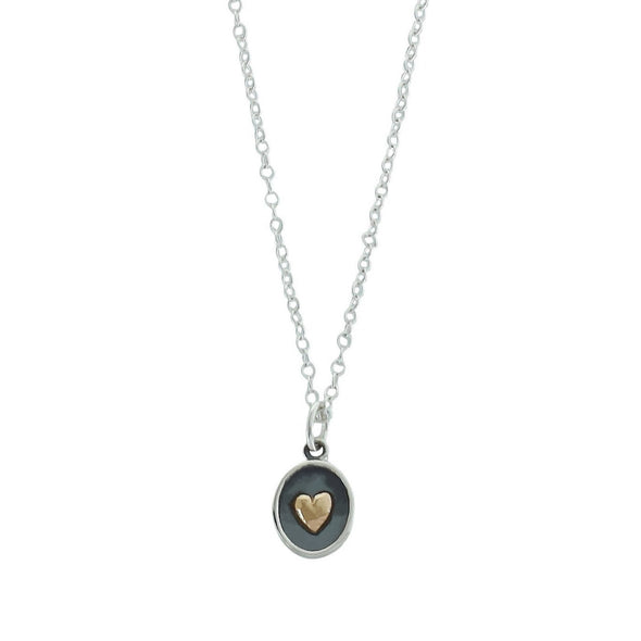 Brass heart on sterling silver oval necklace on white background