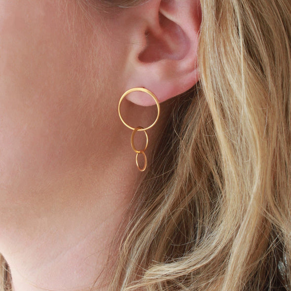 Gold Circles 3 drop stud earrings on model earlobe