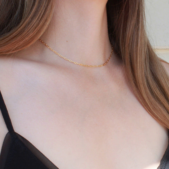 Gold cable chain necklace on models neck