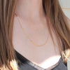 Gold cable chain medium length necklace on models neck