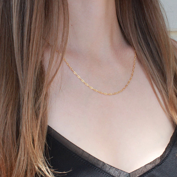 Gold cable chain short length necklace on models neck