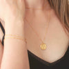 Gold chain bracelets on wrist and gold owl necklace