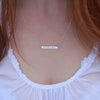 Sterling Silver hand-stamped 'aroha nui' necklace on neck.
