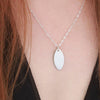 Paua & White Mussel oval shell necklace on neck.