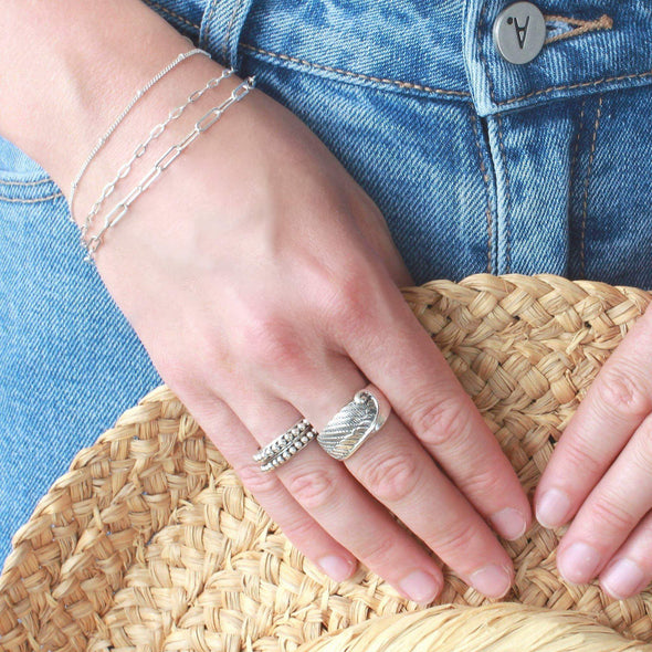 Sterling Silver chain bracelets on wrist and 2 Sterling silver rings