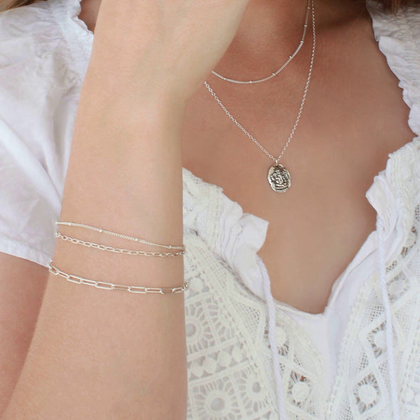 Sterling Silver chain bracelets on wrist and necklaces on neck