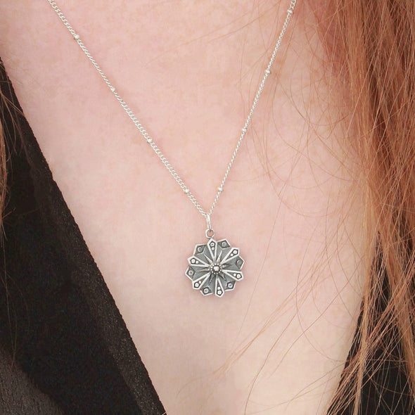 Sterling silver mandala 'courage' necklace on neck.