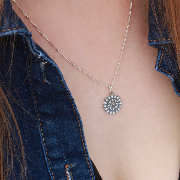 Sterling silver mandala 'resilience' necklace on neck.